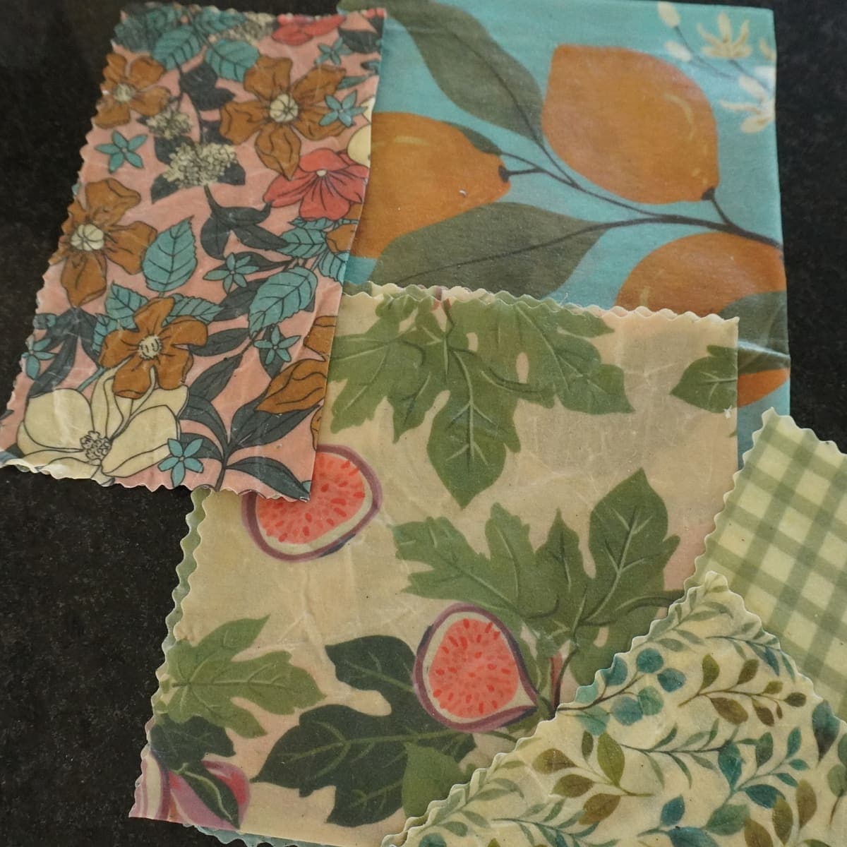 Cuatro wraps de cera de abeja dispuestos en flat lay mostrando variedad de patrones